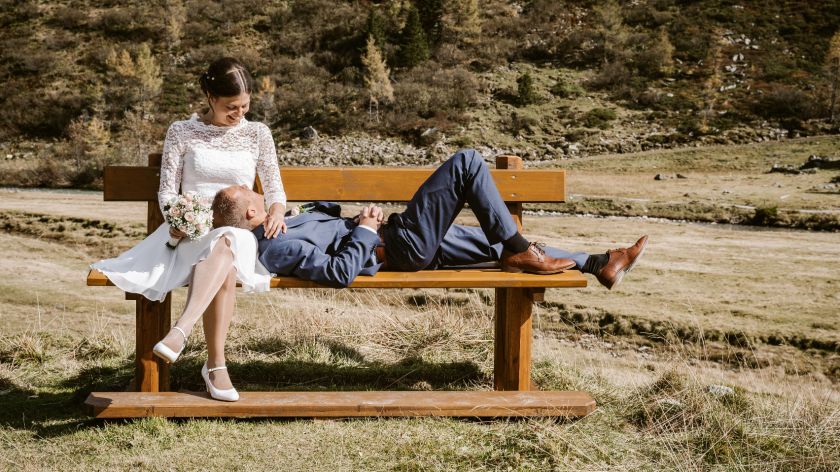 Brautpaar sitzt auf Bank