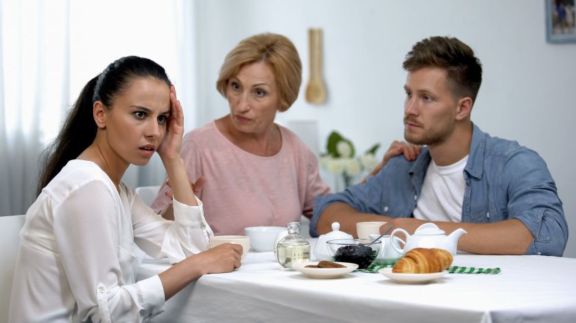 Paar sittzt mit Schwiegermutter am Tisch