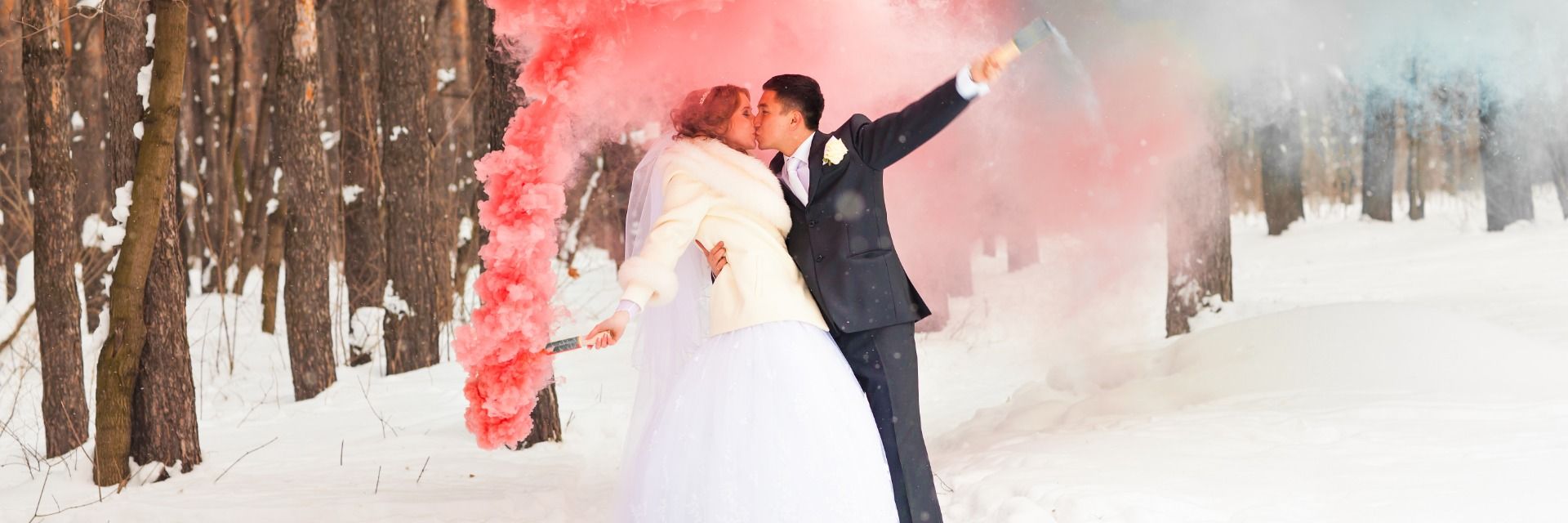 Brautpaar im Schnee mit Farbvulkane